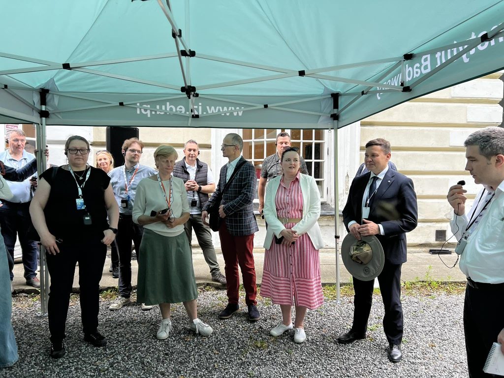 Uczestnicy spotkania zgromadzeni pod namiotem podczas prezentacji na terenie Instytutu.
