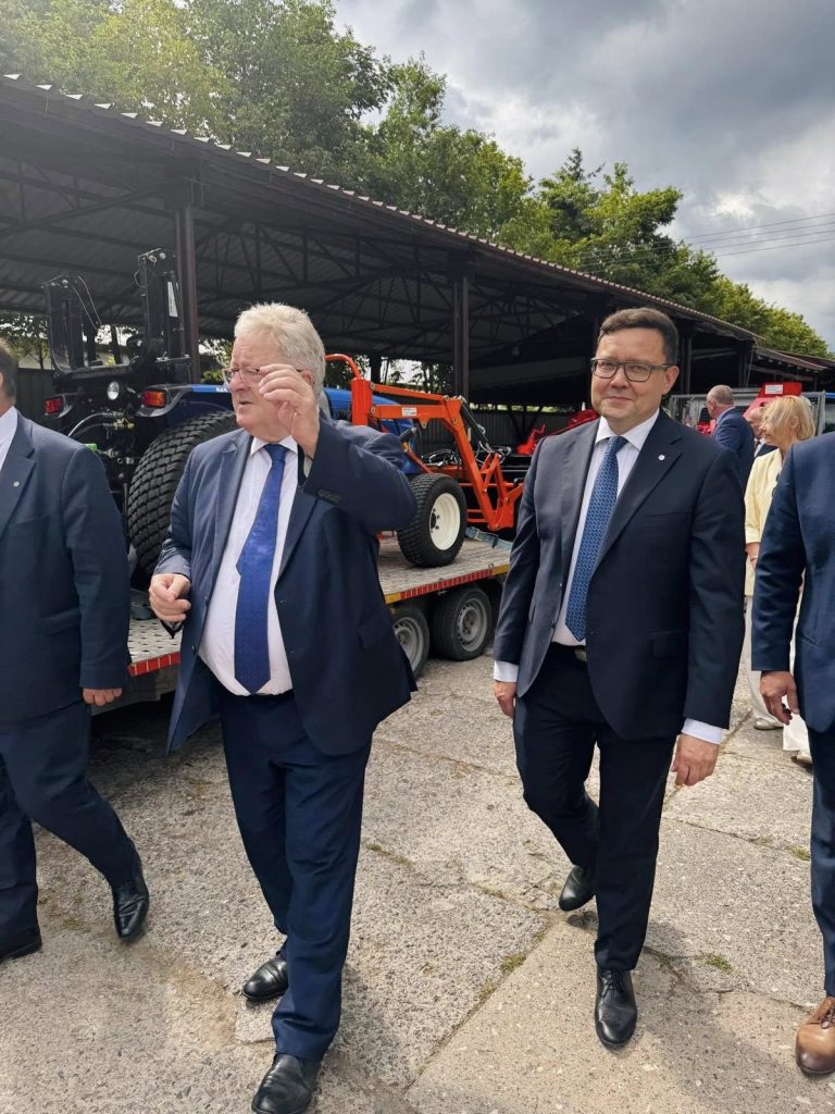 Przedstawiciele instytucji podczas zwiedzania wystawy maszyn rolniczych na terenie wydarzenia branżowego.