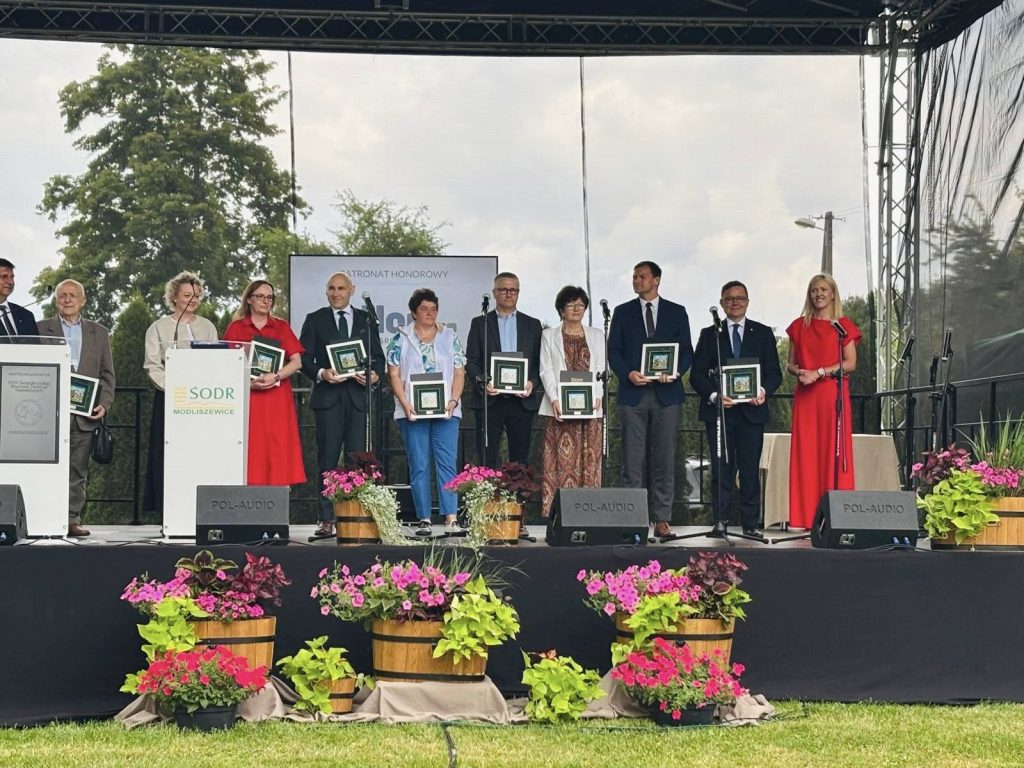 Laureaci uhonorowani podczas ceremonii wręczenia nagród na scenie wydarzenia branżowego.