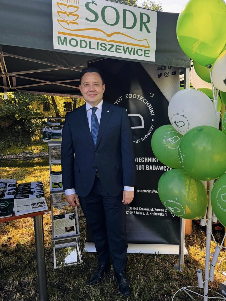 Dyrektor Instytutu Zootechniki PIB przy stoisku promocyjnym podczas wydarzenia plenerowego.