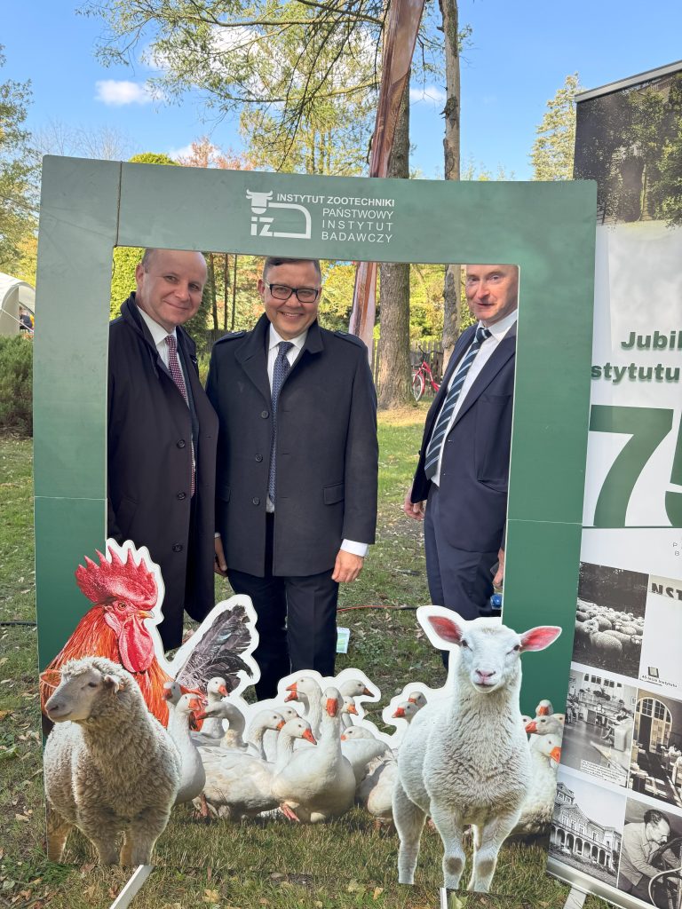 Mężczyźni stoją na tle zieleni w ramce ze zwierzątkami.